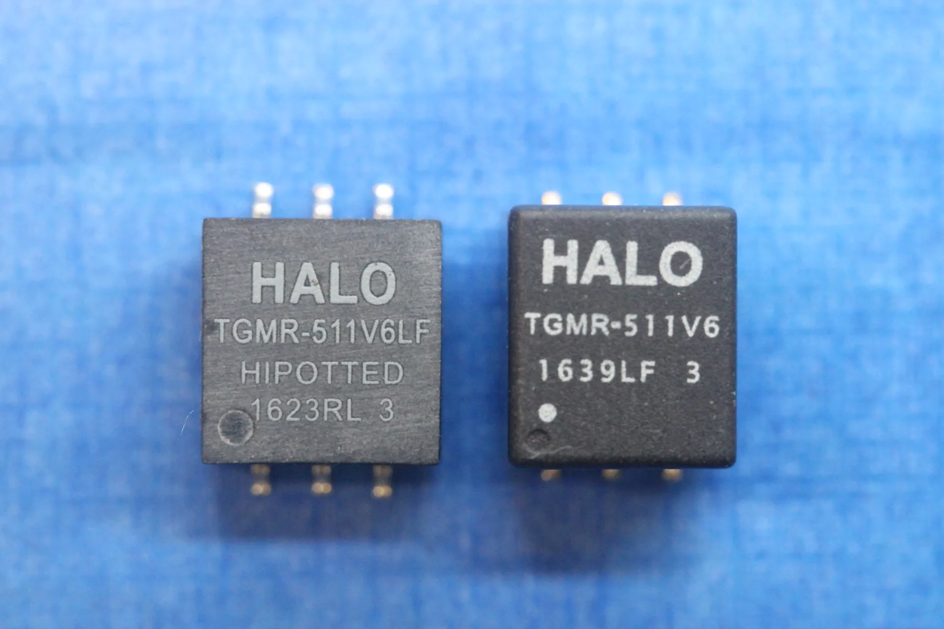 Two electronic components side by side. The two components look similar, but the component on the left looks like it has been sanded down to remove the previous information, and the text font and location is different to the component on the right